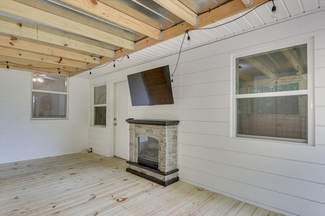 wooden terrace featuring a stone fireplace