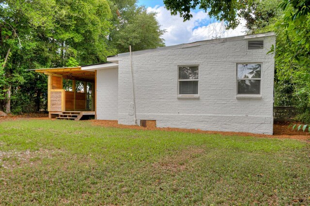 view of side of home with a yard