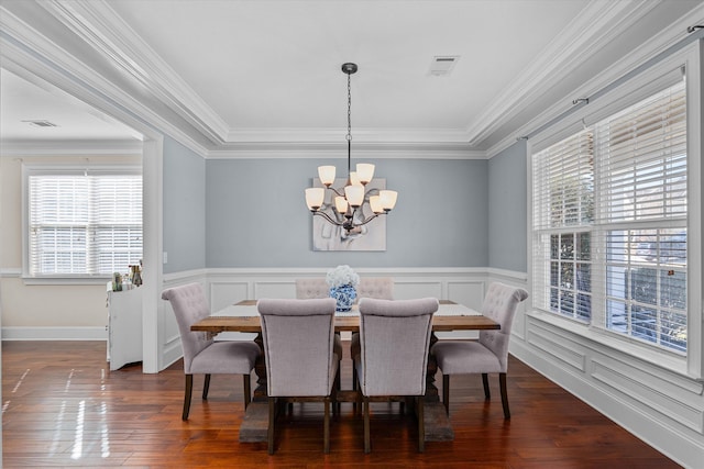 dining space with an inviting chandelier, dark wood-type flooring, and ornamental molding