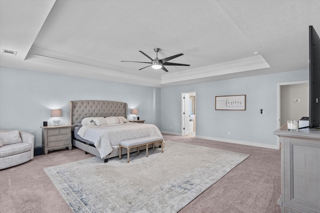 carpeted bedroom featuring ceiling fan, ornamental molding, and a raised ceiling