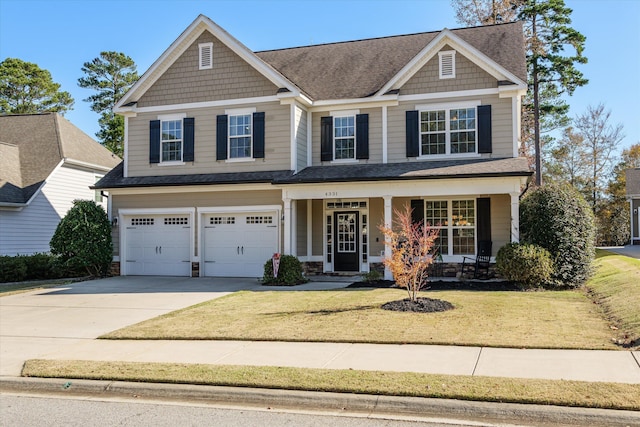 craftsman house with a garage, a front yard, and covered porch