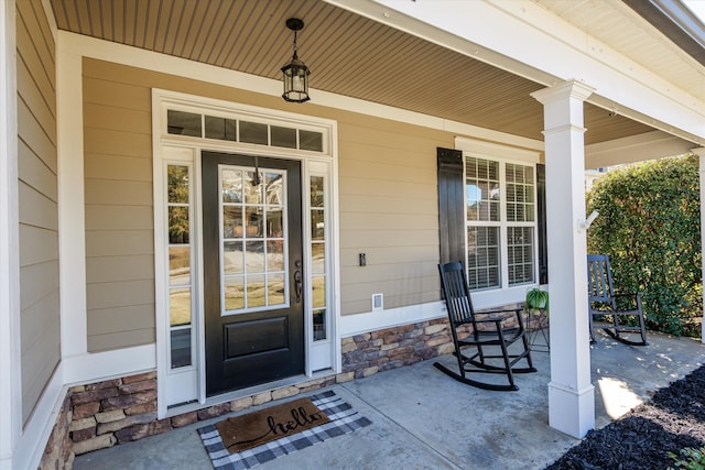 view of exterior entry featuring covered porch