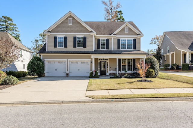 craftsman inspired home featuring covered porch, a garage, and a front lawn