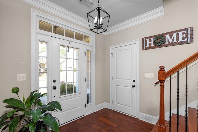 entryway featuring dark wood-type flooring, ornamental molding, and a chandelier