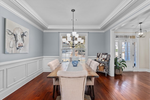 dining space with crown molding, dark wood-type flooring, and an inviting chandelier