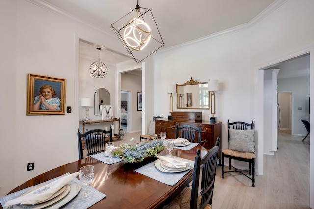 dining room with crown molding, a chandelier, light wood-type flooring, and baseboards
