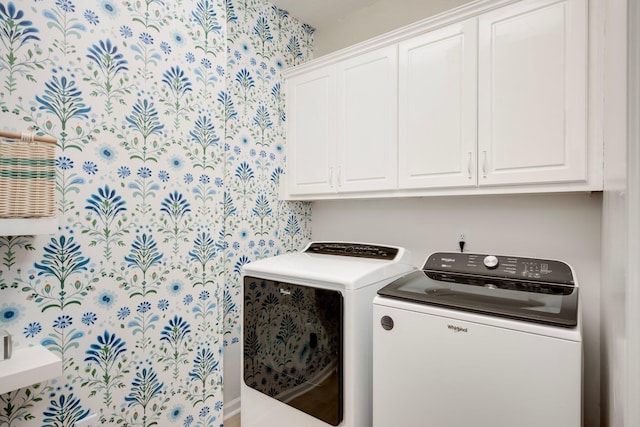 washroom with wallpapered walls, cabinet space, and independent washer and dryer