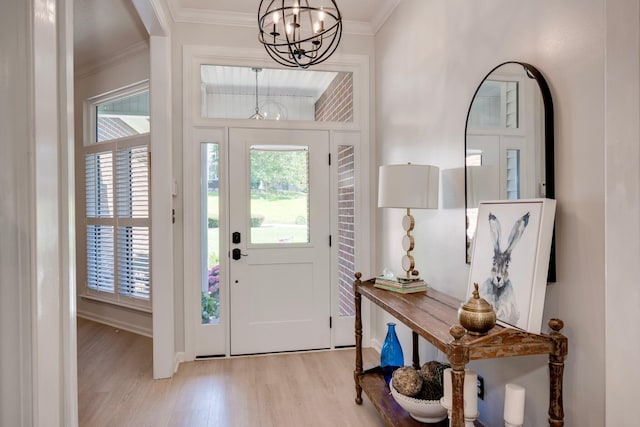 entryway featuring a chandelier, wood finished floors, and crown molding