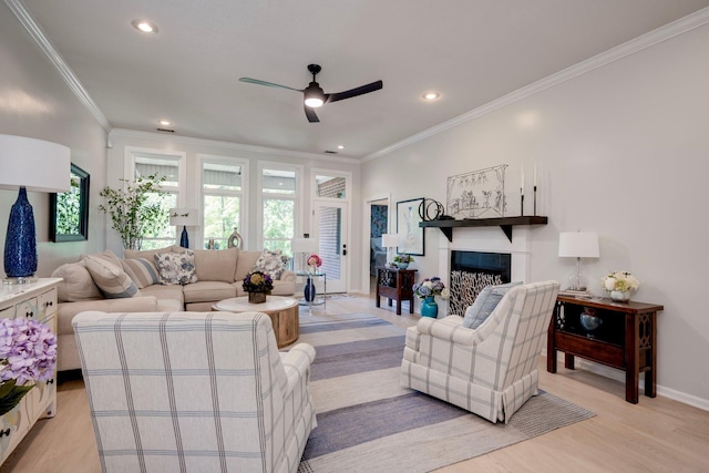 living area with ceiling fan, healthy amount of natural light, light wood-style flooring, recessed lighting, and crown molding