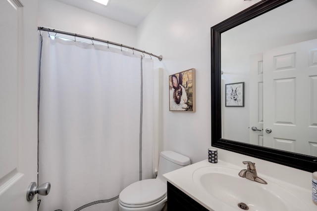 bathroom featuring toilet, vanity, and a shower with curtain
