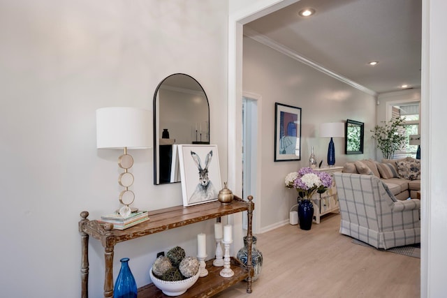 corridor featuring ornamental molding, light wood finished floors, baseboards, and recessed lighting