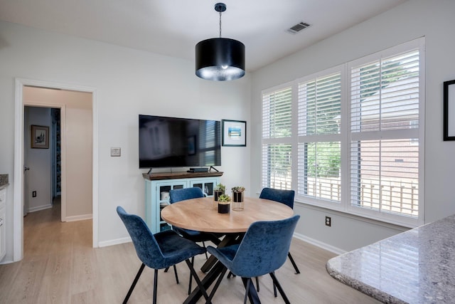 dining space featuring light wood-type flooring and baseboards