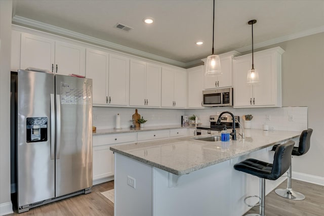 kitchen with white cabinets, appliances with stainless steel finishes, a sink, light wood finished floors, and visible vents
