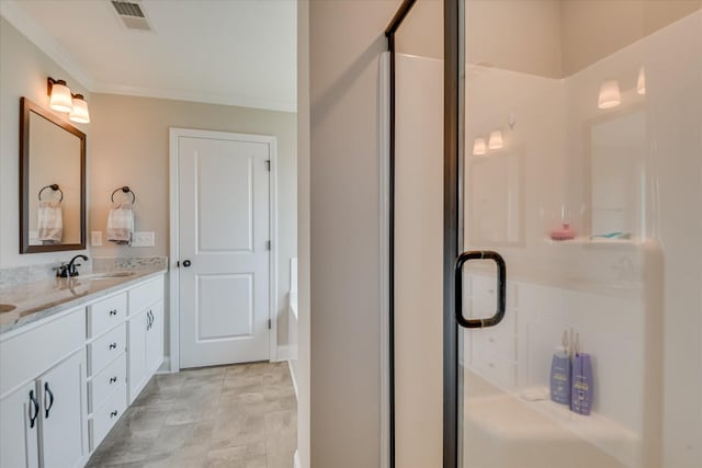 full bath with double vanity, visible vents, crown molding, a shower stall, and a sink