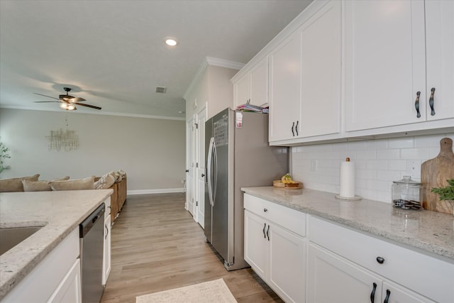 kitchen with ornamental molding, ceiling fan, white cabinetry, tasteful backsplash, and appliances with stainless steel finishes