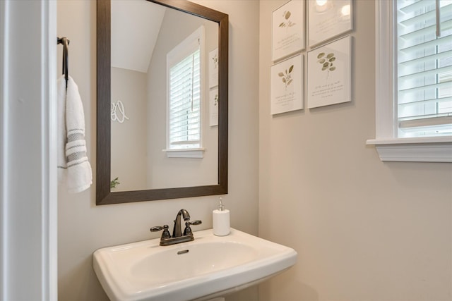 bathroom with a sink and lofted ceiling