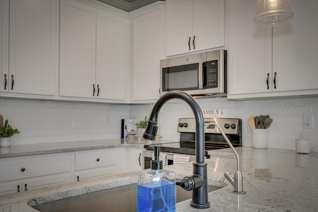 kitchen with appliances with stainless steel finishes, decorative backsplash, and white cabinetry