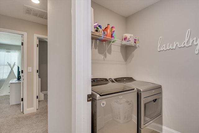 washroom featuring laundry area, visible vents, baseboards, separate washer and dryer, and light carpet