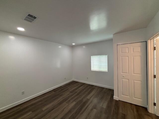 875 Earle St, Thomson, GA 30824 - unfurnished bedroom featuring dark wood-style flooring, baseboards, recessed lighting, and a closet
