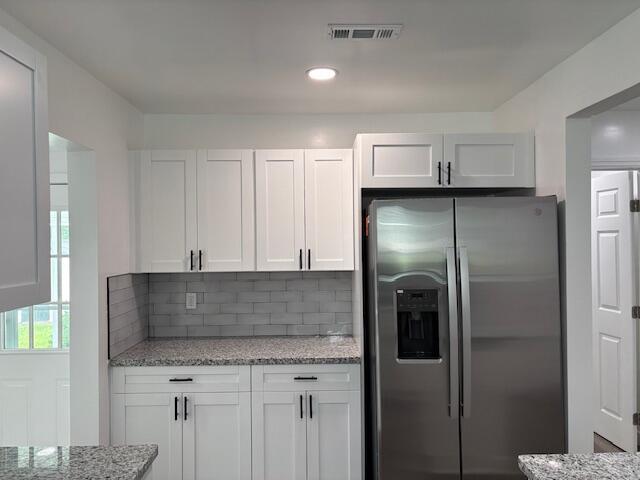 875 Earle St, Thomson, GA 30824 - kitchen featuring stainless steel fridge, white cabinetry, backsplash, light stone countertops, and recessed lighting