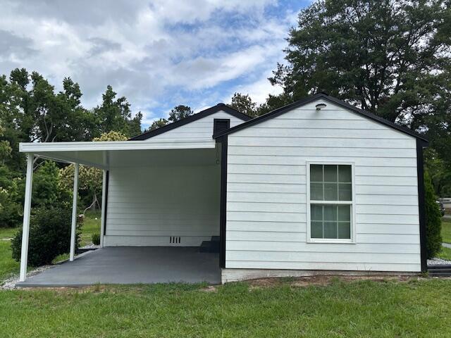 875 Earle St, Thomson, GA 30824 - view of property exterior featuring a yard and an attached carport