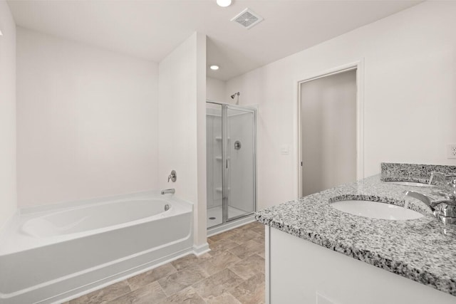 bathroom with a stall shower, visible vents, a sink, and a garden tub