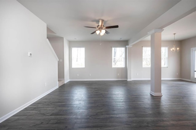 unfurnished living room with ornate columns, baseboards, dark wood-style flooring, and ceiling fan with notable chandelier