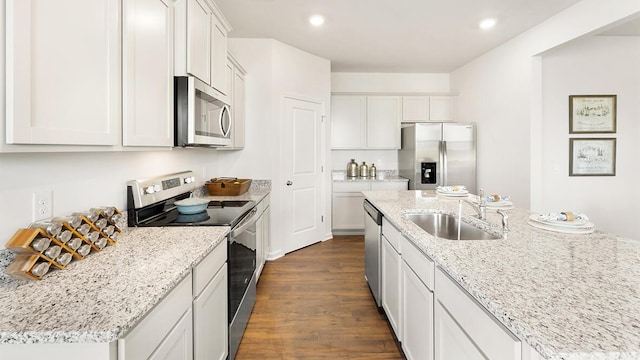 kitchen with white cabinets, dark wood-style flooring, stainless steel appliances, a sink, and recessed lighting