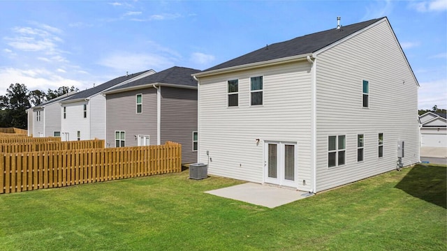 back of house featuring fence, central AC, and a yard