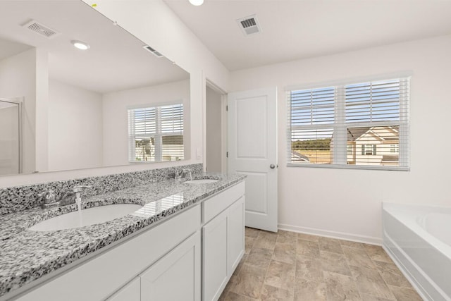 full bath with a garden tub, visible vents, and a sink