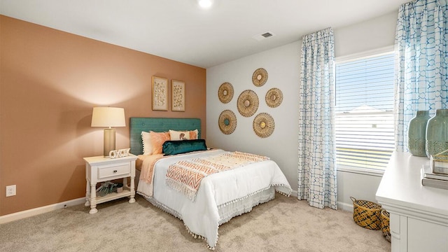 bedroom with visible vents, light carpet, and baseboards