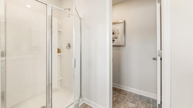 bathroom featuring a stall shower and baseboards