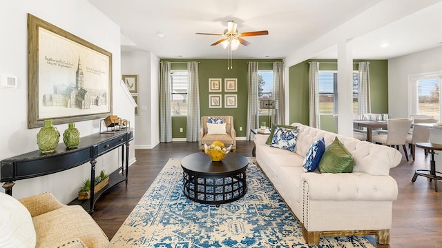 living room featuring ceiling fan, baseboards, and wood finished floors