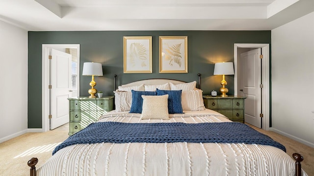 carpeted bedroom featuring baseboards and a raised ceiling