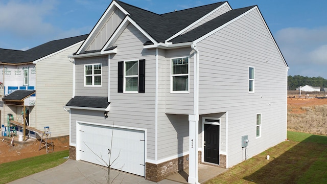 view of front of property featuring a garage, concrete driveway, a front lawn, board and batten siding, and brick siding