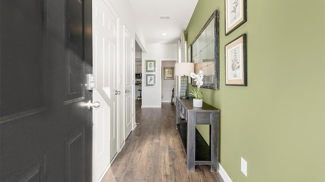 corridor with wood finished floors, visible vents, and baseboards