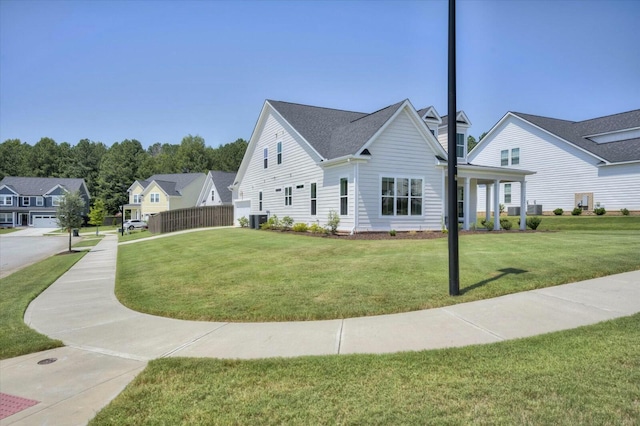 view of home's exterior with a residential view, central AC unit, fence, and a yard