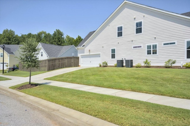 view of property exterior featuring a yard, concrete driveway, and fence