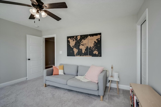 living room with baseboards, a ceiling fan, and light colored carpet