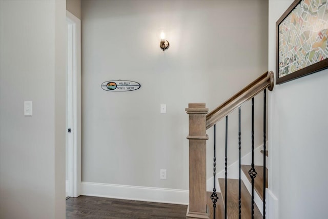 staircase with baseboards and wood finished floors