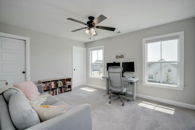 carpeted home office with a ceiling fan, visible vents, and baseboards