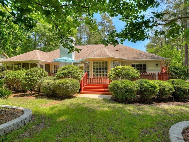 back of house featuring a sunroom and a yard