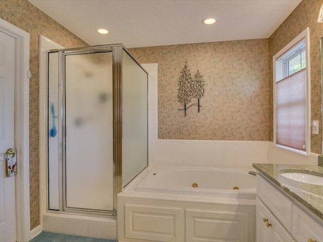 bathroom featuring a textured ceiling, vanity, and independent shower and bath