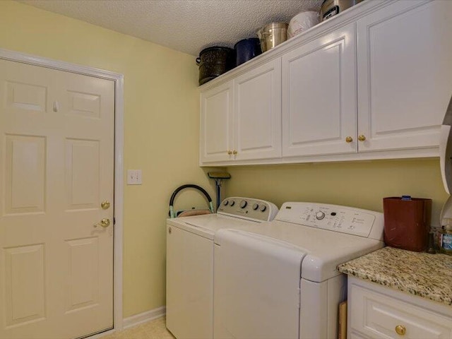 clothes washing area with washing machine and dryer, light carpet, cabinets, and a textured ceiling