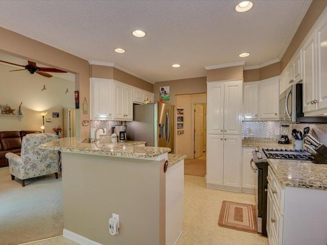 kitchen with backsplash, white cabinetry, and appliances with stainless steel finishes