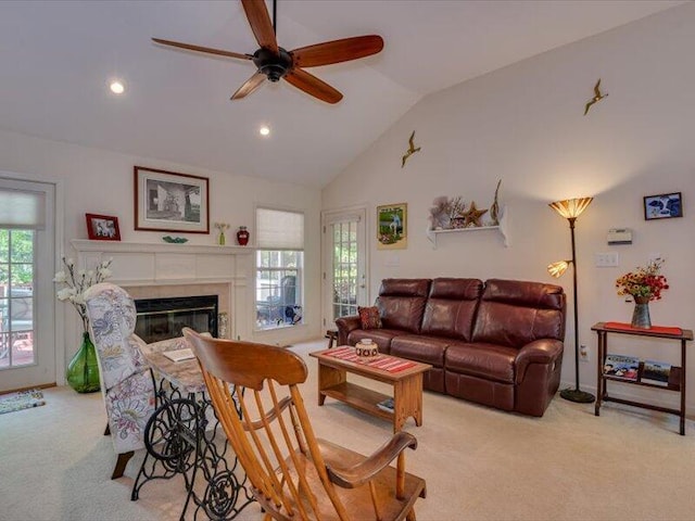 living room featuring ceiling fan, a healthy amount of sunlight, vaulted ceiling, and light carpet