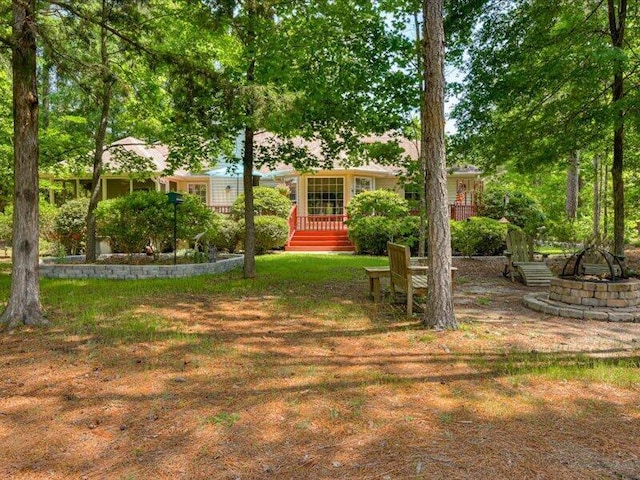 view of yard with a deck and an outdoor fire pit