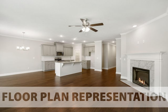 kitchen with hanging light fixtures, stainless steel appliances, an island with sink, a breakfast bar area, and a fireplace