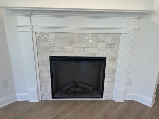 interior details featuring a fireplace, baseboards, and wood finished floors