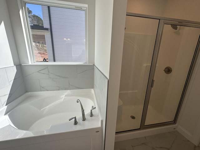 bathroom featuring a garden tub, marble finish floor, and a stall shower